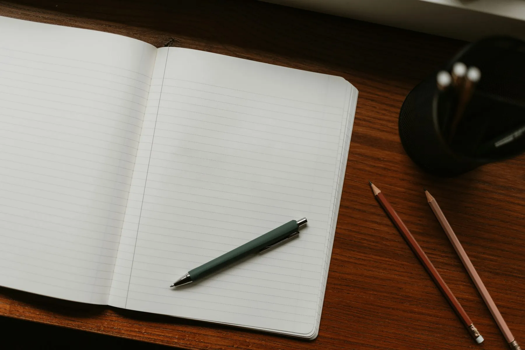 A student typing on a laptop while writing an application