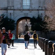 Students walking through a university campus archway