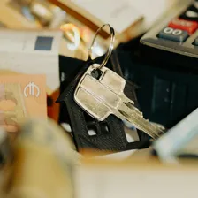 A calculator next to a pile of coins on a desk