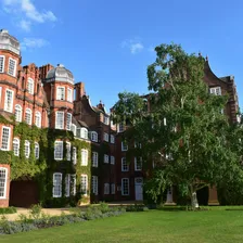 A UK university campus building with ivy-covered red brick